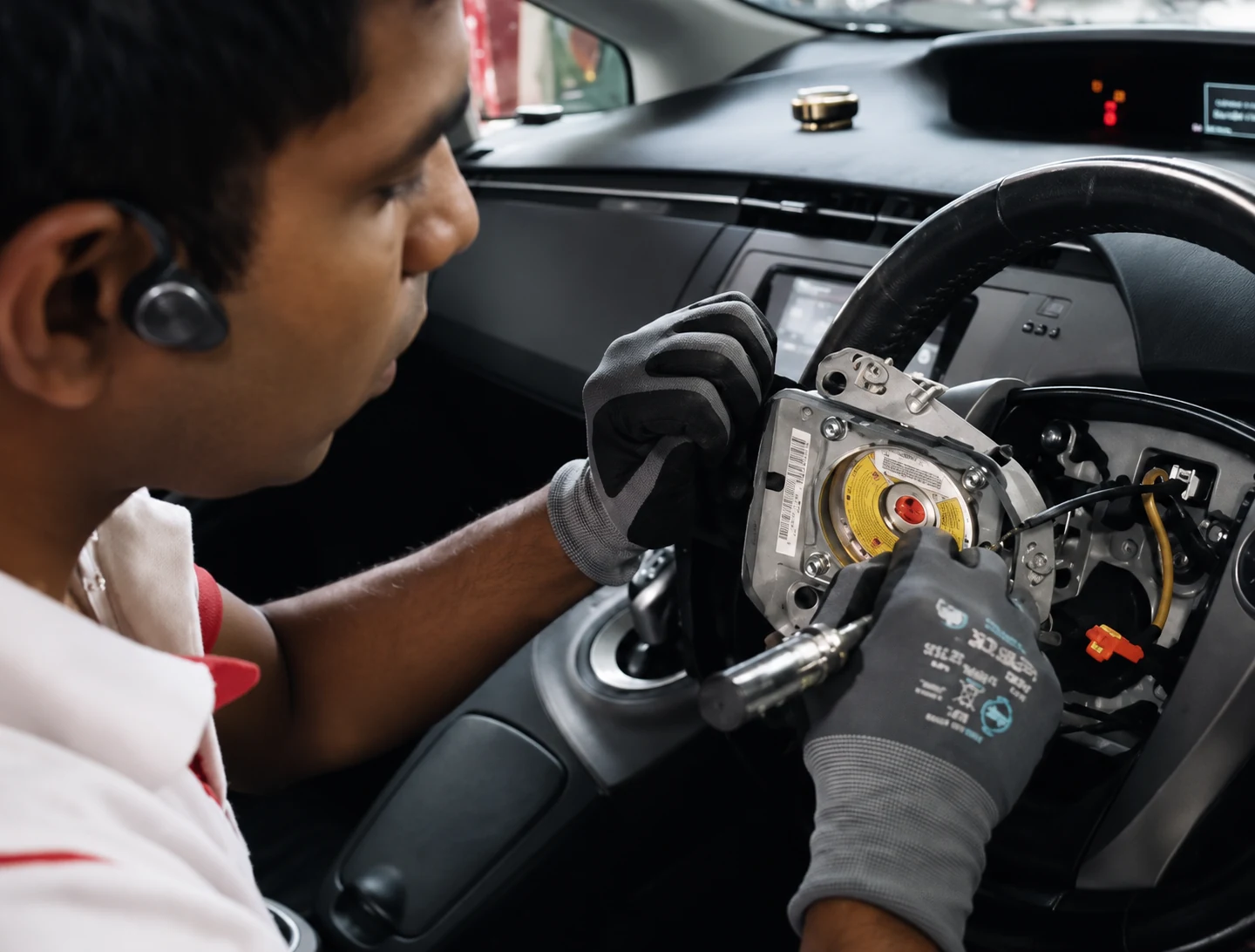 Technician inspecting steering-wheel safety electronics